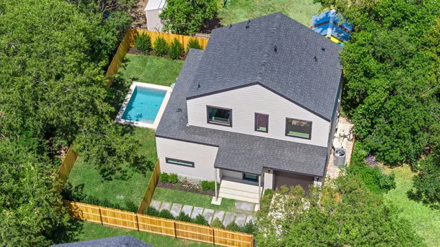 a aerial view of a house with a yard and large tree