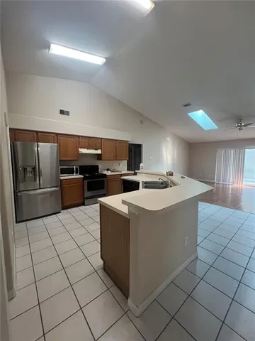 a kitchen with stainless steel appliances a refrigerator and a stove top oven