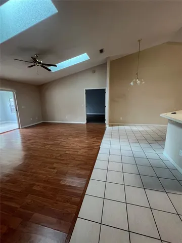 a view of a livingroom with an empty space and a ceiling fan