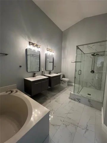 a bathroom with a double vanity sink mirror and shower