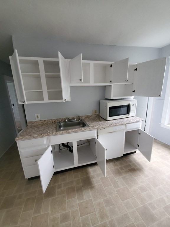 8 Knowlton Avenue Worcester, MA 01603 - Photo 9 of 35 a kitchen with a stove a sink and a refrigerator