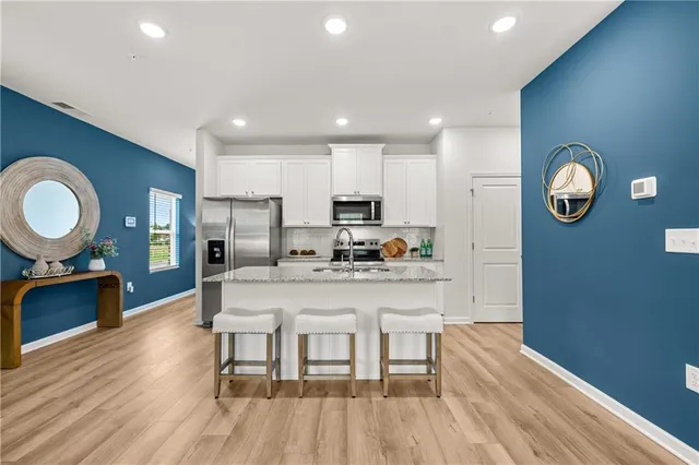 a large kitchen with a wooden floor and a refrigerator