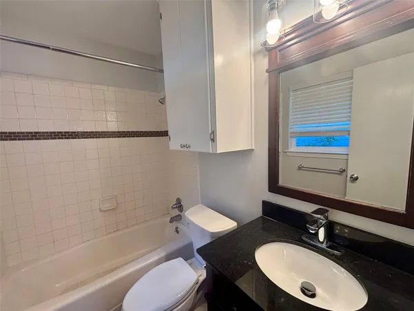 a bathroom with a sink vanity granite toilet tub and shower