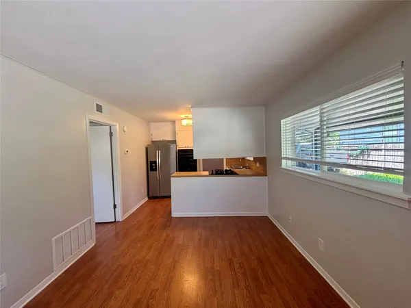 a view of a kitchen with wooden floor and electronic appliances