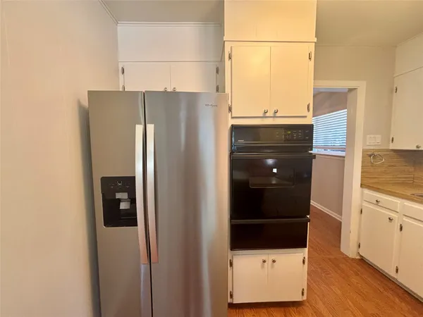 a kitchen with a refrigerator and a stove top oven