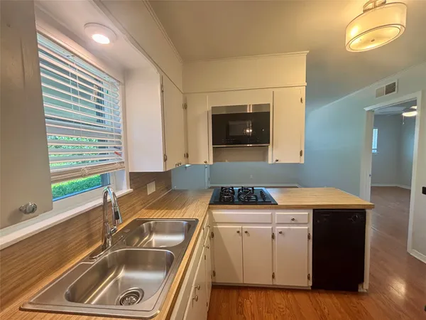 a kitchen that has a sink a stove and a window