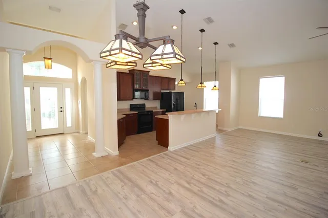 a view of a big room with wooden floor and chandelier