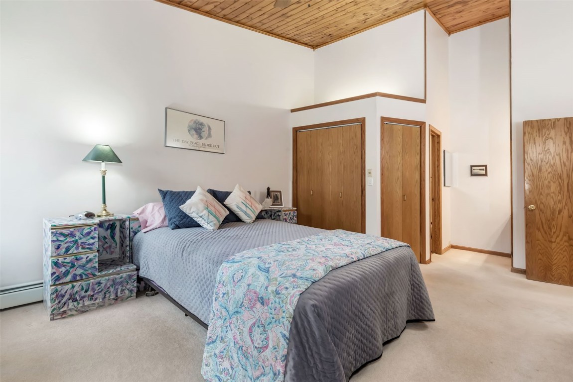2116 Aster Place Steamboat Springs, CO 80487 - Photo 18 of 42 a spacious bedroom with a bed and a lamp