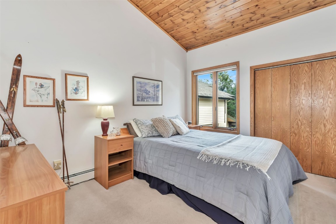 2116 Aster Place Steamboat Springs, CO 80487 - Photo 22 of 42 a bedroom with a bed a table and painting on the wall