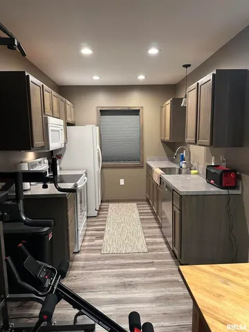 a kitchen with kitchen island a counter top space a sink a stove and a refrigerator