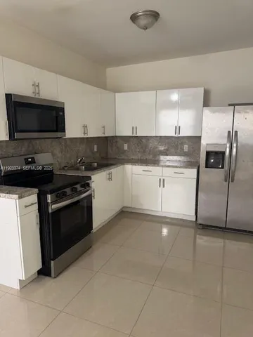 a kitchen with granite countertop a sink and a stove top oven