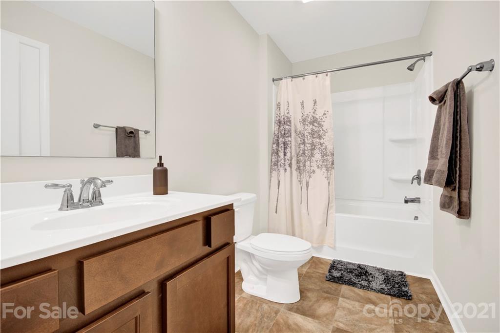 9026 Colwick Hill Road Charlotte, NC 28215 - Photo 17 of 21 a bathroom with a sink toilet a mirror and shower