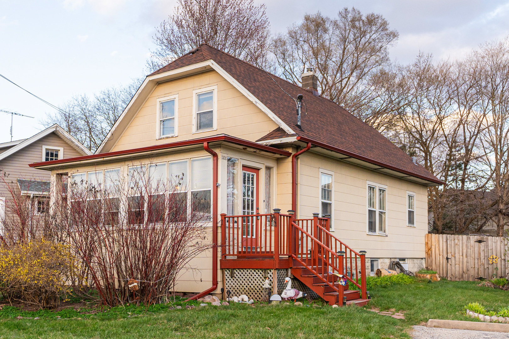 a front view of a house with a yard and deck