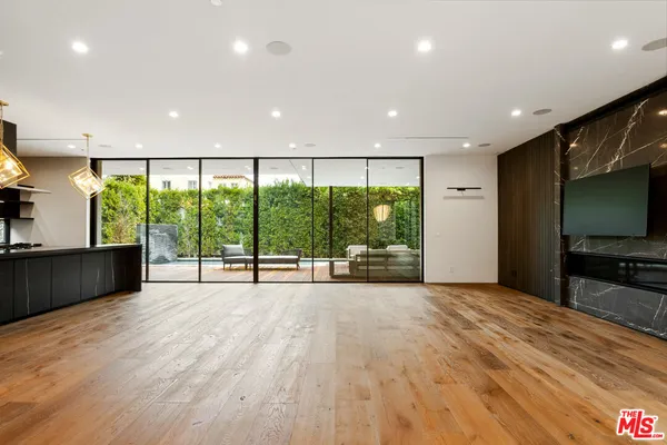 a living room with a flat screen tv and a wooden floor