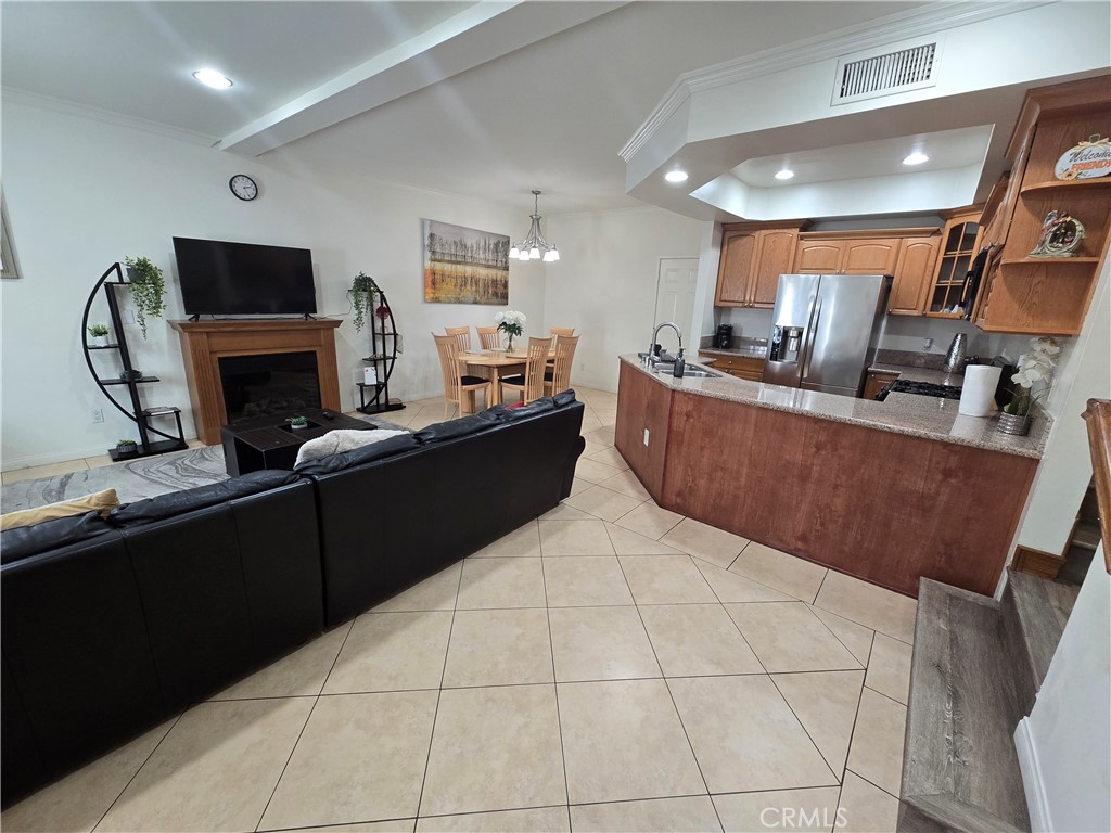 8026 Telegraph Road Downey, CA 90240 - Photo 6 of 26 a living room with furniture a fireplace and a flat screen tv