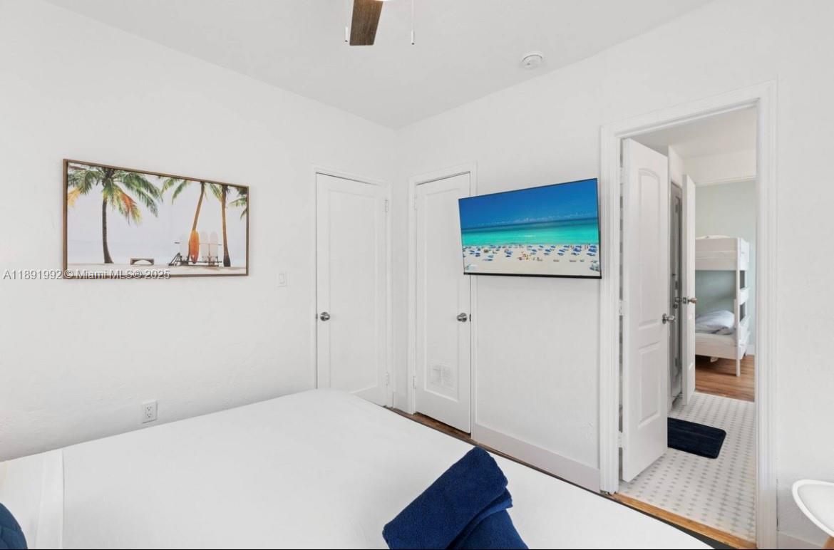 7721 Harding Avenue, Unit 4 Miami Beach, FL 33141 - Photo 12 of 16 a bedroom with a bed and a painting on the wall