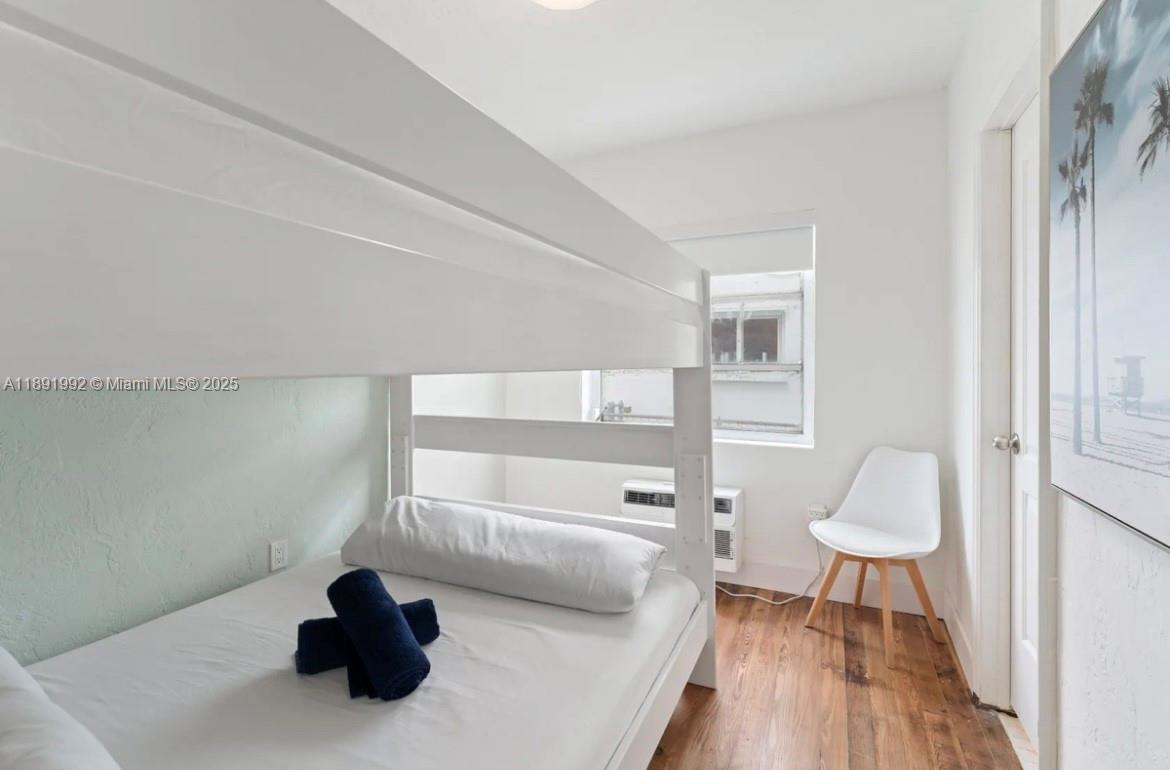 7721 Harding Avenue, Unit 4 Miami Beach, FL 33141 - Photo 14 of 16 a bedroom with a bed and a chair