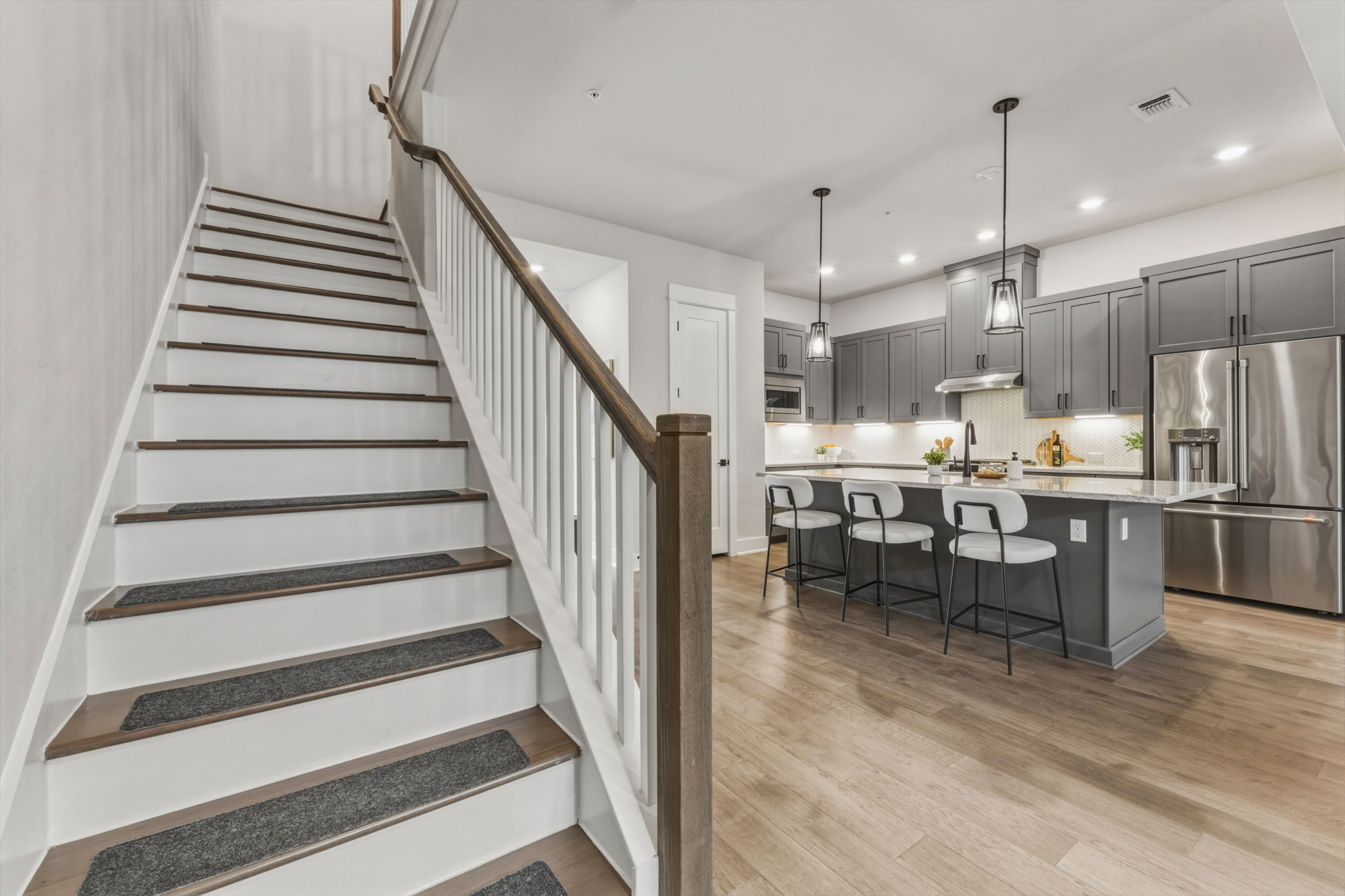 2929 Moreno Street Austin, TX 78723 - Photo 21 of 40 Modern kitchen featuring gray cabinetry, stainless steel appliances, and a central island with pendant lighting
