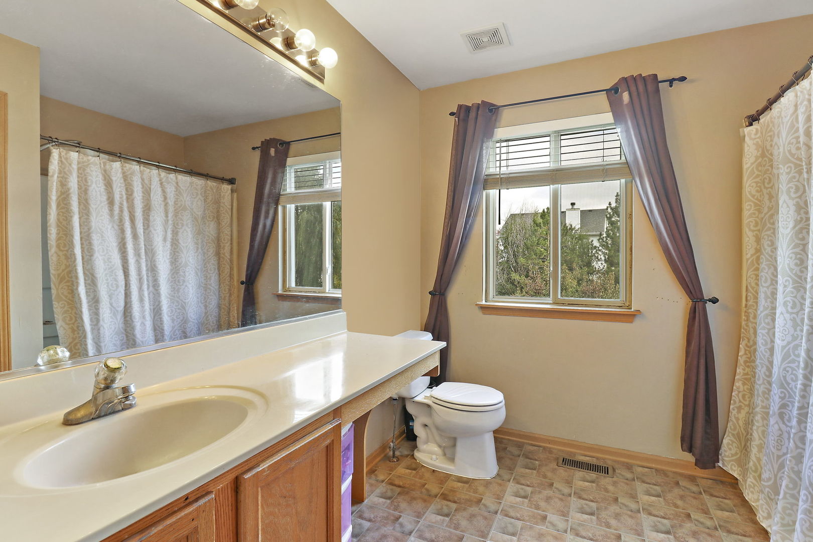 5511 Windgate Way Lake In The Hills, IL 60156 - Photo 14 of 30 a bathroom with a sink a toilet and a mirror