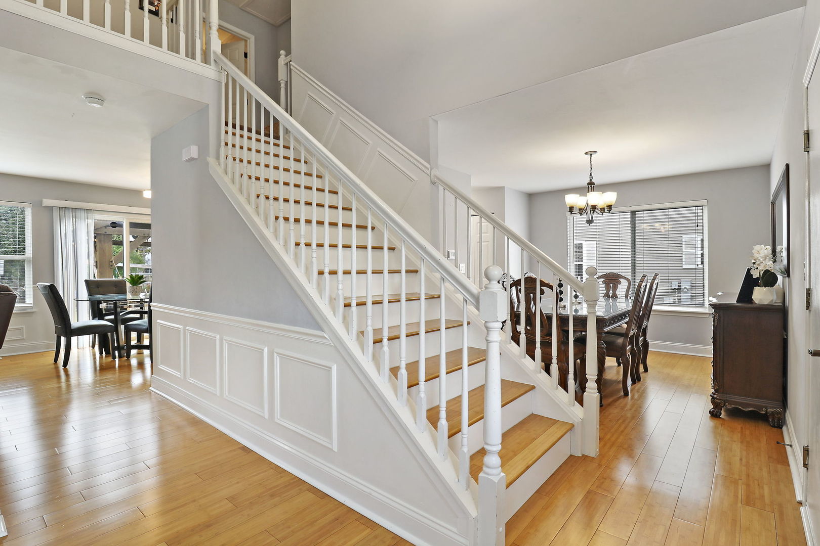 5511 Windgate Way Lake In The Hills, IL 60156 - Photo 4 of 30 a view of staircase and dining room with wooden floor and a chandelier