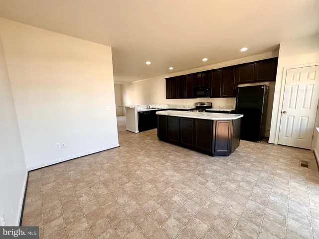 a view of kitchen with stainless steel appliances granite countertop refrigerator sink and stove