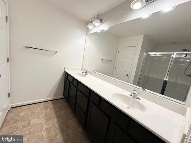 a bathroom with a double vanity sink a and a mirror