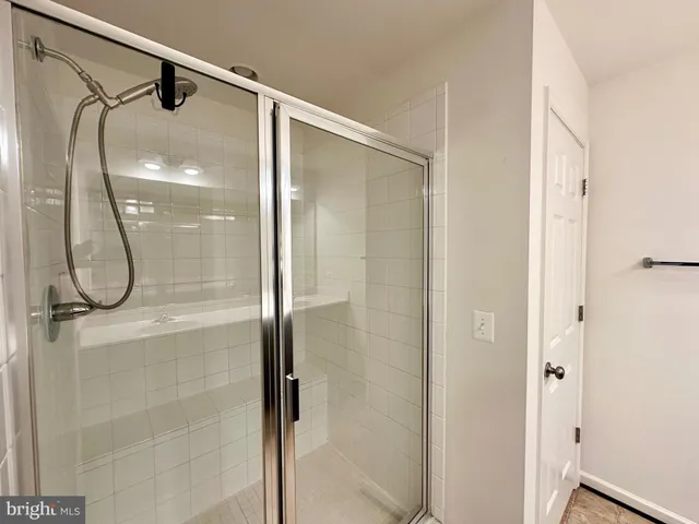 a bathroom with a glass shower door and mirror