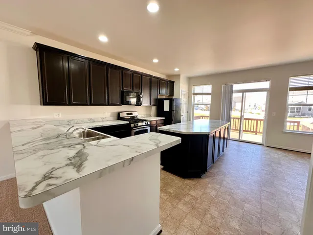 a kitchen with a refrigerator and a stove top oven