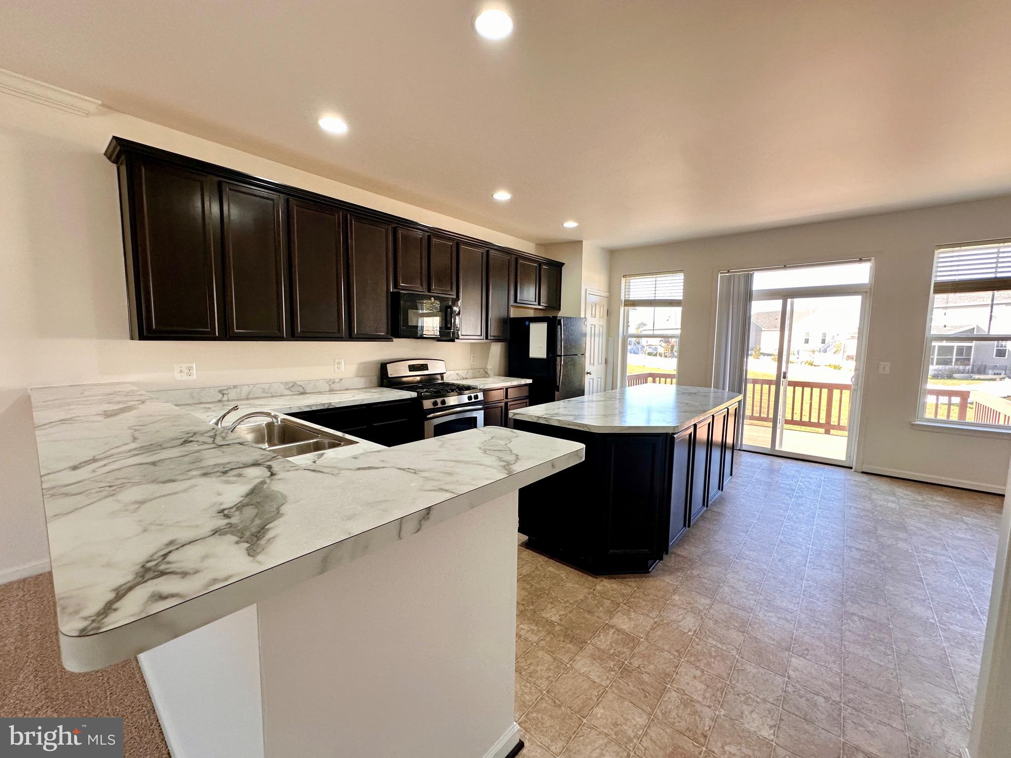 111 Fading Star Court Stephenson, VA 22656 - Photo 7 of 25 a kitchen with a refrigerator and a stove top oven