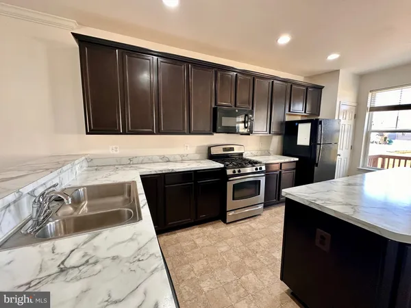 a kitchen with granite countertop wooden cabinets and stainless steel appliances