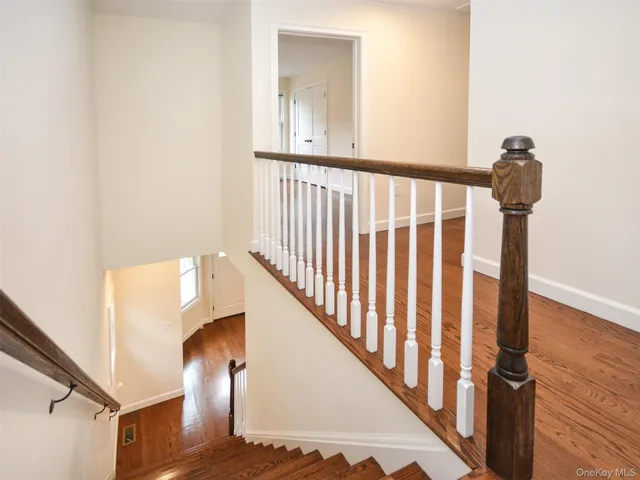 a view of a hallway with wooden floor and staircase