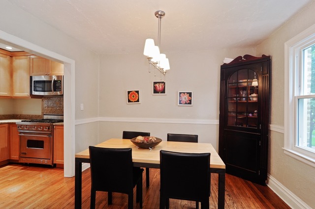 2138 Illinois Road Northbrook, IL 60062 - Photo 5 of 15 a dining room with wooden floor a chandelier a wooden table and chairs