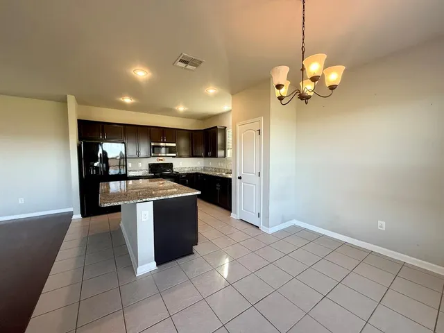 a kitchen with stainless steel appliances granite countertop a refrigerator a sink and a stove