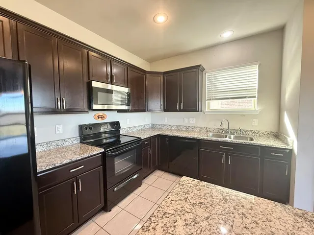 a kitchen with a sink stove and refrigerator
