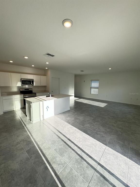 724 Reggie Road Winter Haven, FL 33859 - Photo 5 of 26 a large kitchen with stainless steel appliances kitchen island