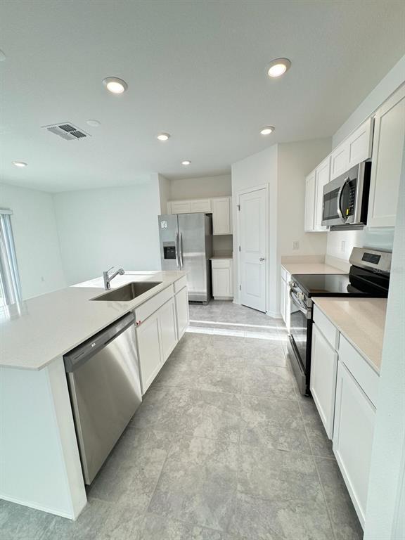 724 Reggie Road Winter Haven, FL 33859 - Photo 6 of 26 a kitchen with stainless steel appliances a stove a sink and a refrigerator