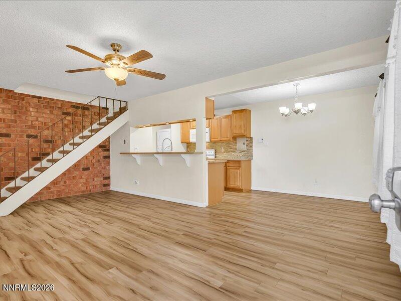 a view of a kitchen with wooden floor and a ceiling fan