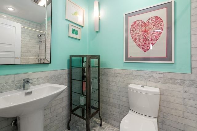 a bathroom with a toilet sink and mirror