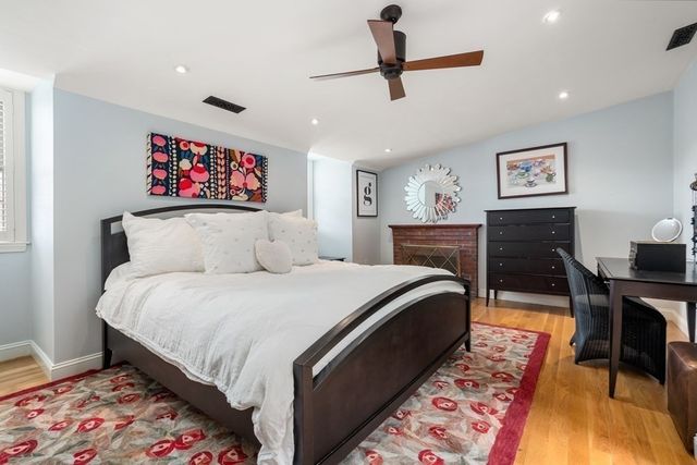 a bedroom with a bed and a lamp on dresser