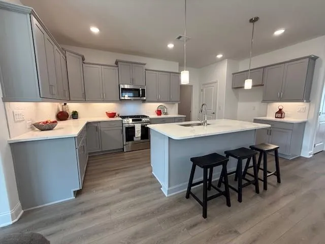a kitchen with a sink cabinets and wooden floor