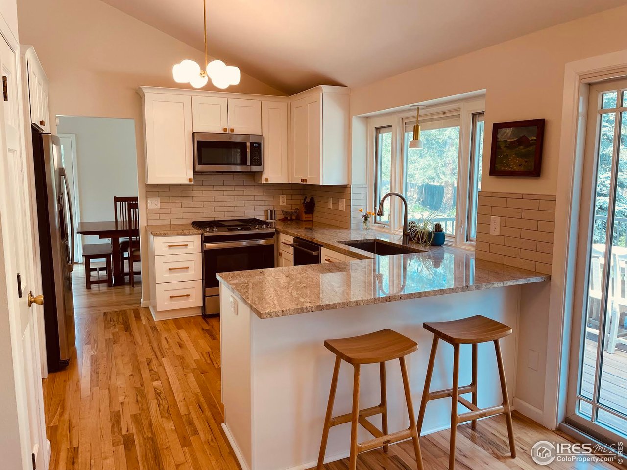 4303 30th Street Boulder, CO 80301 - Photo 12 of 37 a kitchen with stainless steel appliances granite countertop a stove top oven a refrigerator a sink and chairs