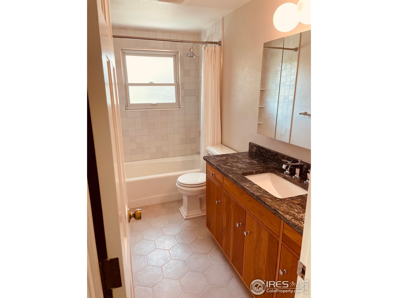 4303 30th Street Boulder, CO 80301 - Photo 28 of 37 a bathroom with a granite countertop sink a toilet and a mirror