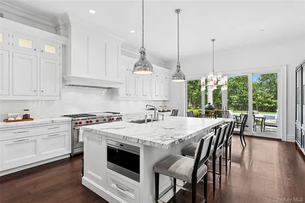 a kitchen with stainless steel appliances granite countertop a stove a kitchen island a stove a table and chairs