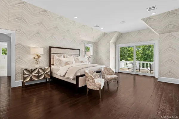 a bed sitting in a spacious bedroom next to a window