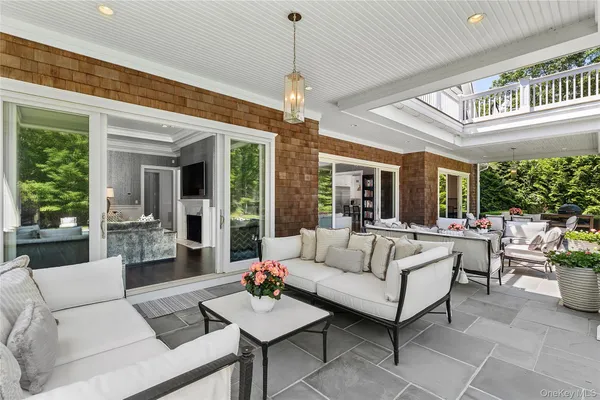 a living room with patio furniture and a chandelier