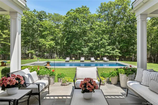 a view of a patio with couches table and chairs and potted plants