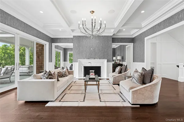 a living room with furniture a fireplace and a chandelier