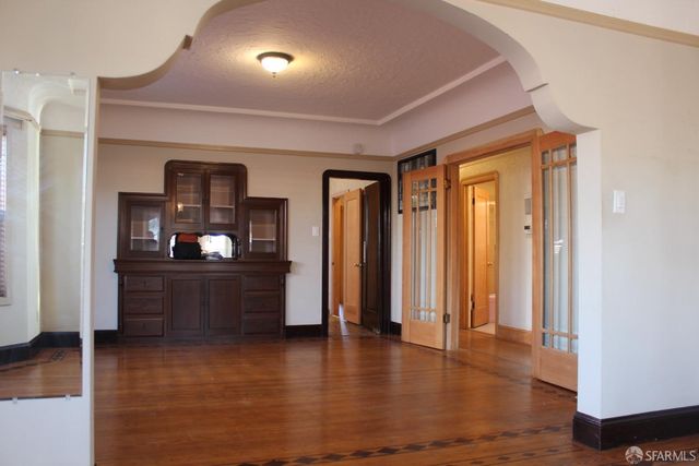 a view of a hallway with wooden floor and windows