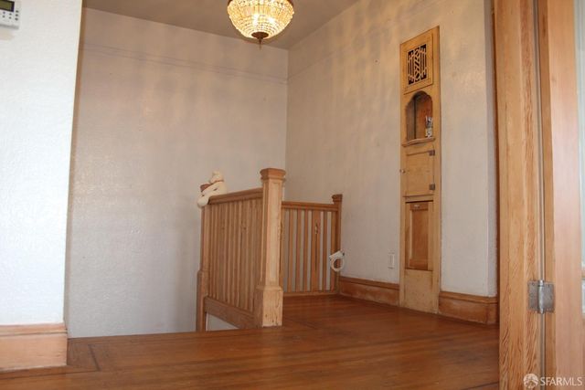 an empty room with wooden floor and closet