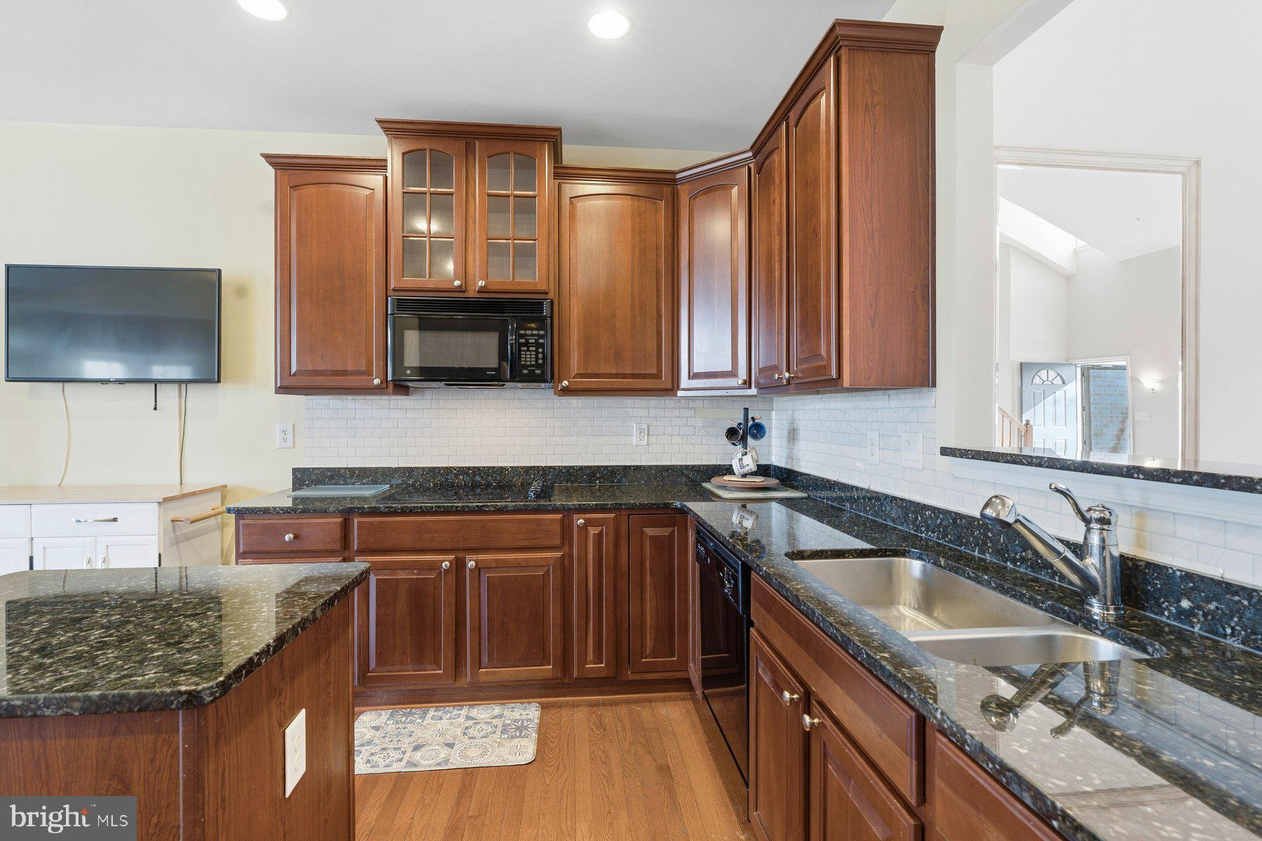 8330 Meadowsweet Road, Unit 8330 Pikesville, MD 21208 - Photo 9 of 55 a kitchen with granite countertop a sink stove and cabinets